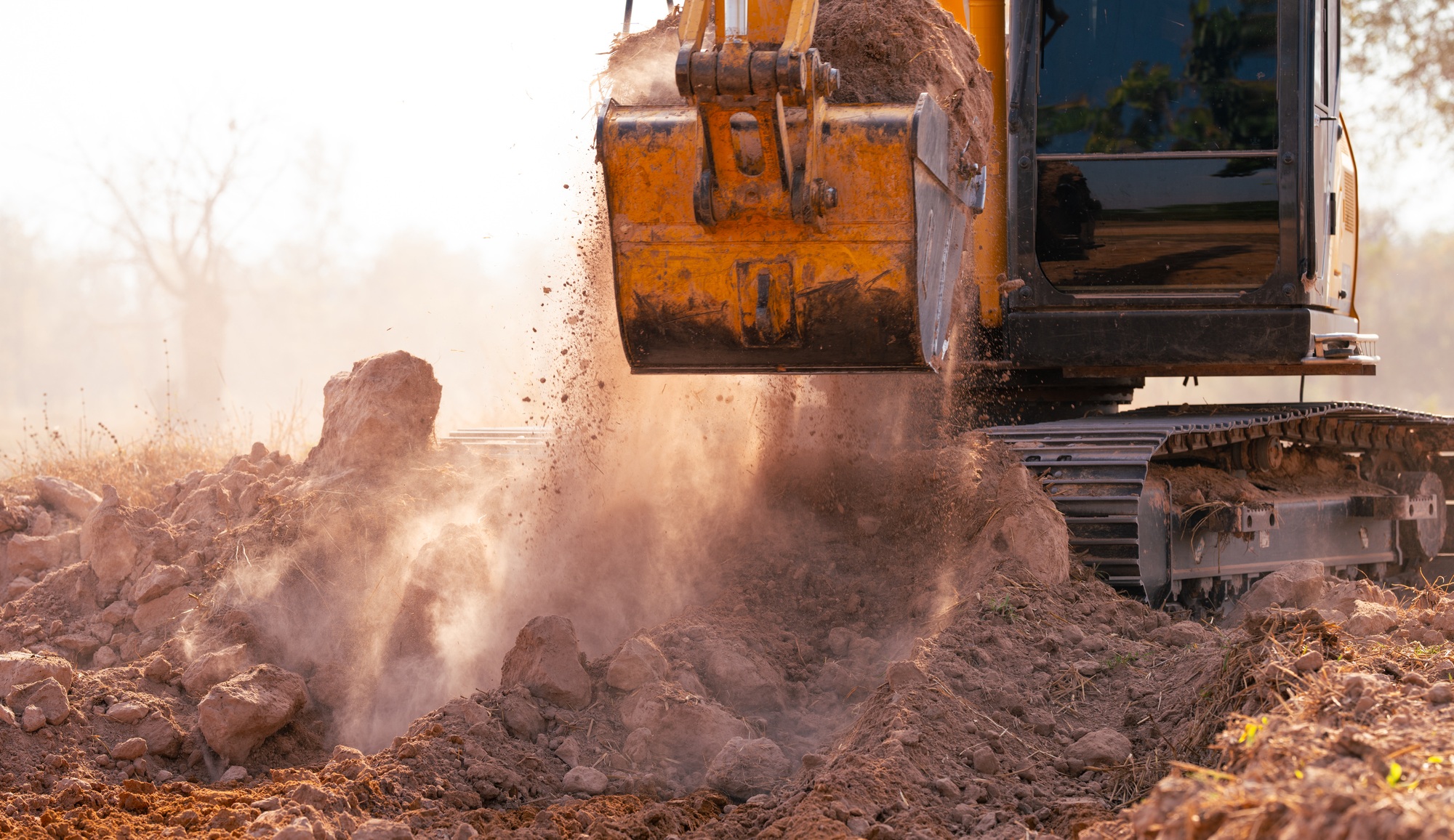 Close-up of excavator at construction site. Backhoe digging soil for earthwork and construction