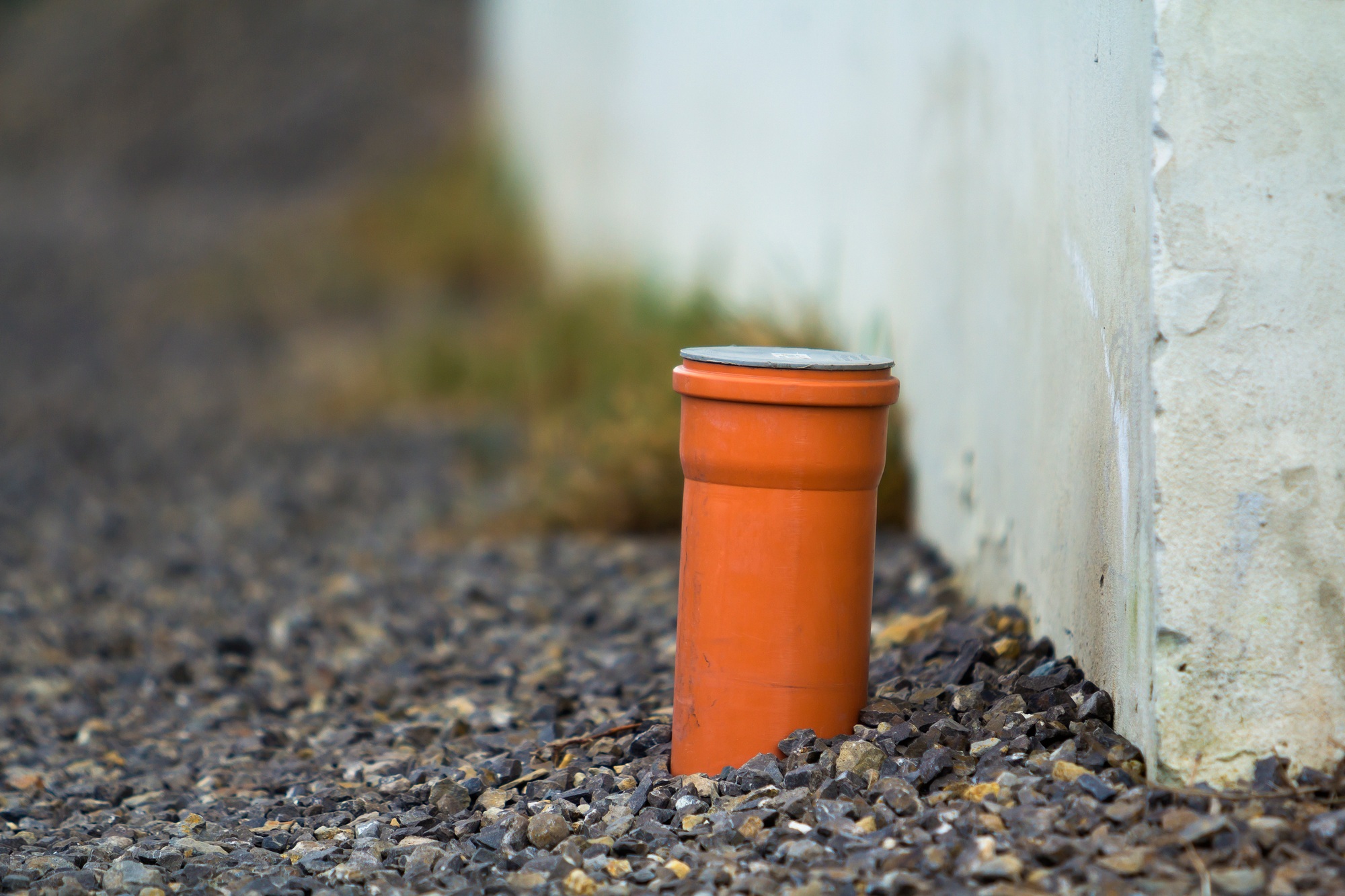 Drainage pipe in the recess of the gutter. Pipe for the water sticking from the ground